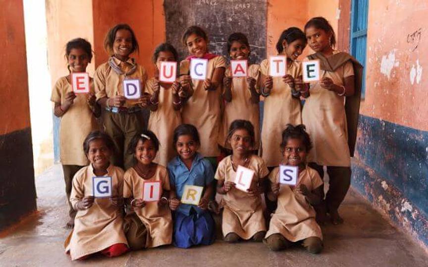 Group of twelve Indian girls holding letters to spell out the words, "Educate Girls"